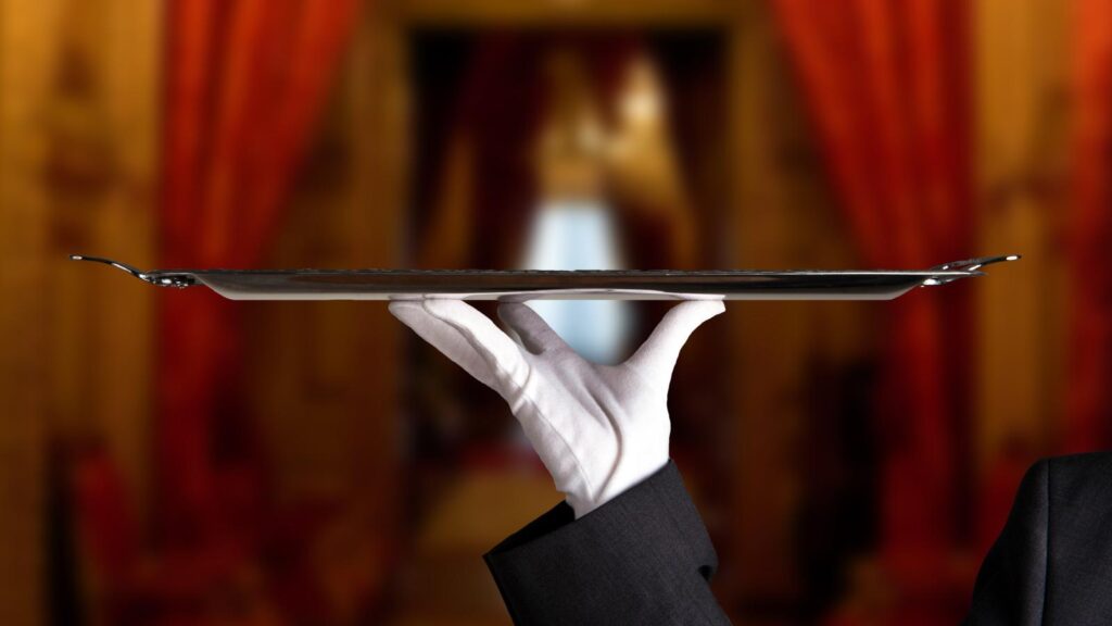 luxury service - white gloved hand holding silver platter