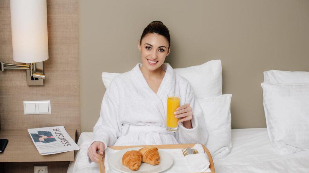 woman eating breakfast in bed at hotel