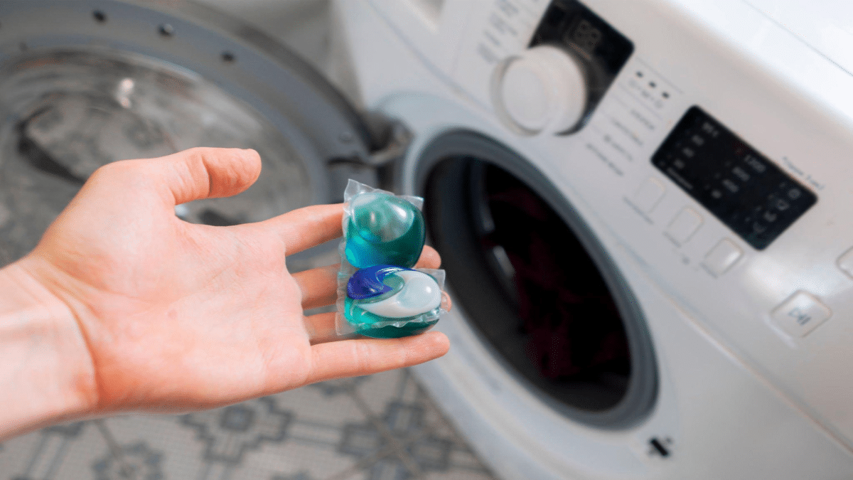 Михаил-Руденко-persons-hand-put-special-cleaning-pod-or-capsule-in-the-washing-machine-with-dirty-clothes.png