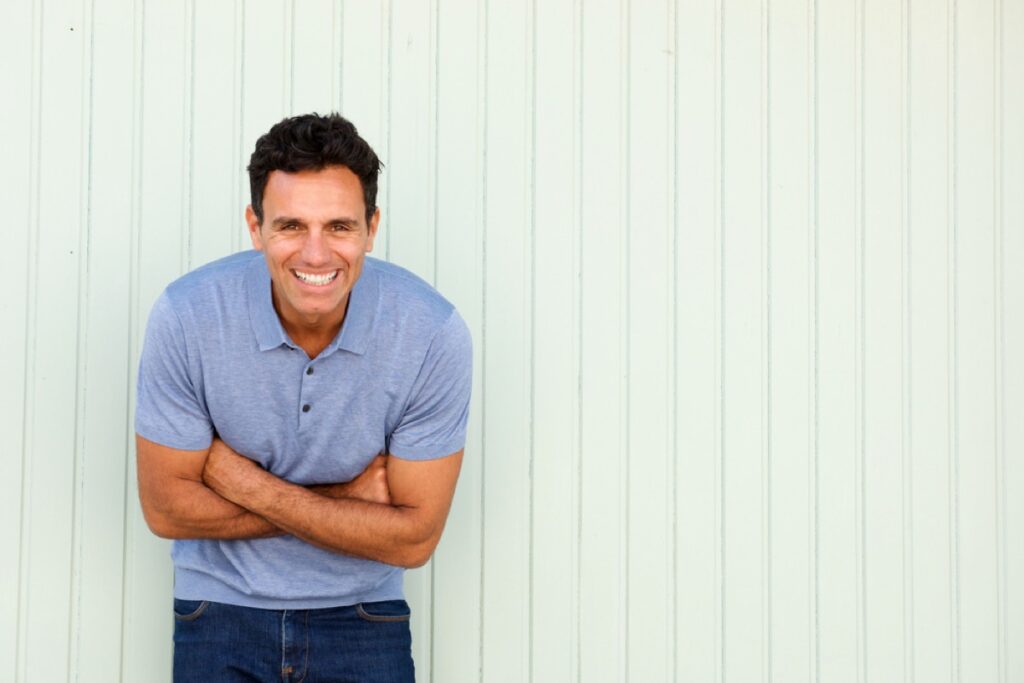 Portrait of cool middle age man laughing with arms crossed