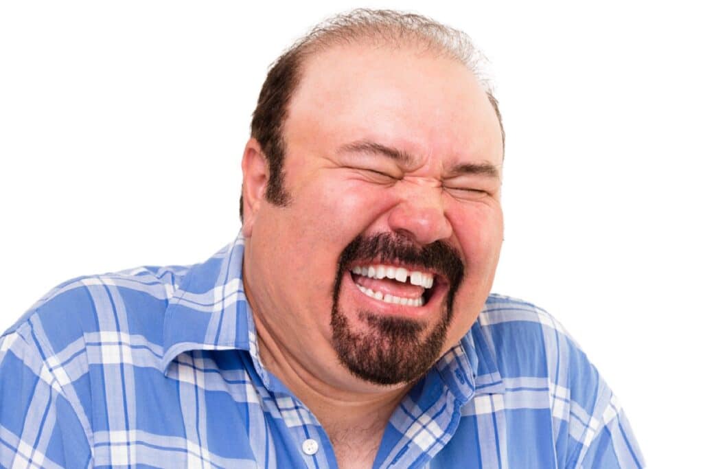 Portrait of a middle-aged Caucasian bearded happy man laughing loud, isolated on white background