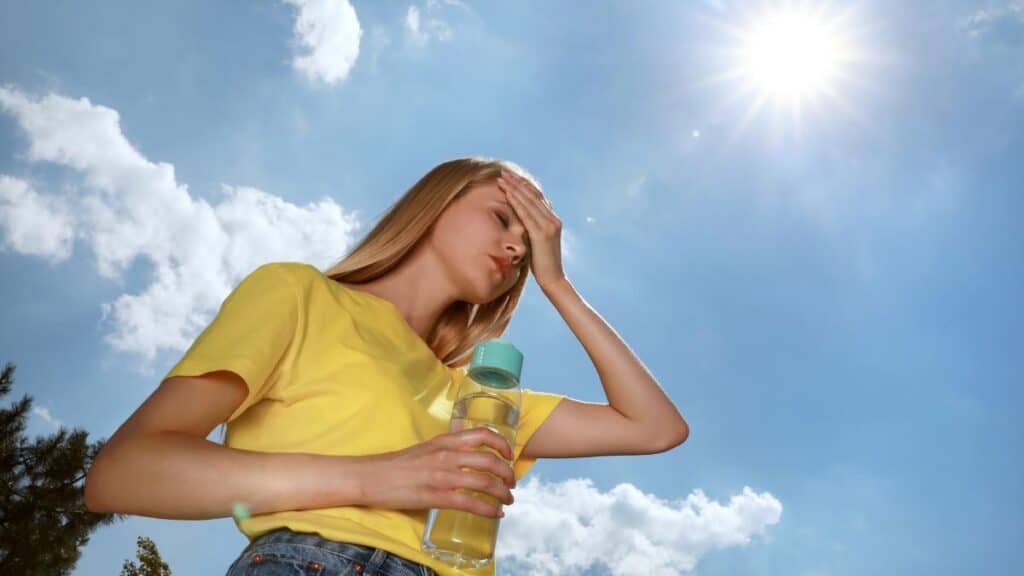 woman in yellow shirt too hot in sun