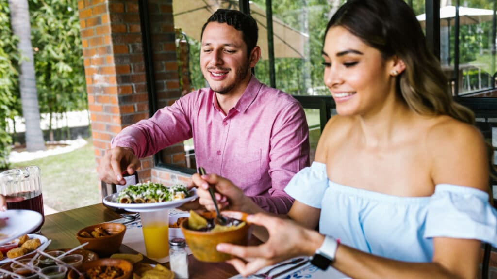 Mexican man and woman eating - Marcos CastilloShutterstock